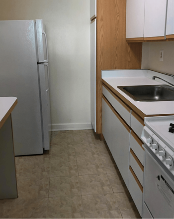 A kitchen with a white fridge, white oven and white sink.